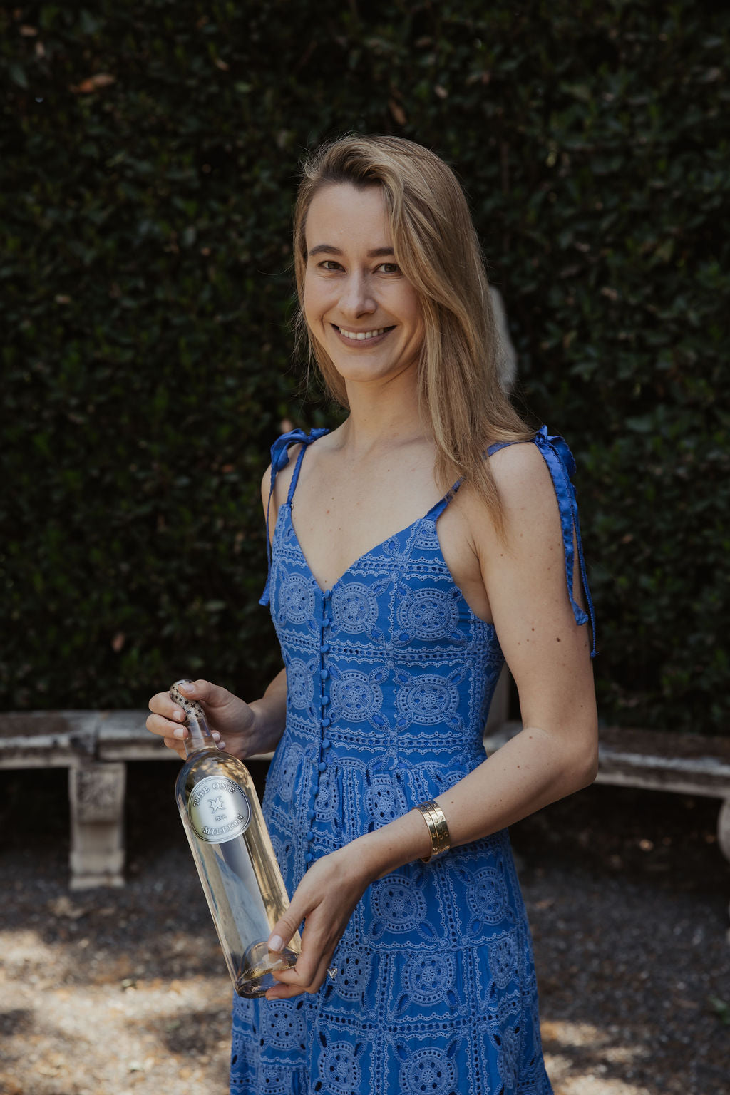Founder and second generation vintner Greta Montgomery holding a bottle of her one in a million white wine.