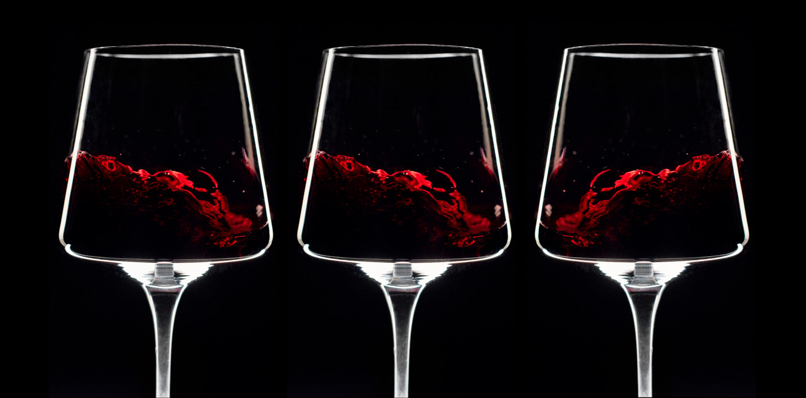 Three wine glasses filled with ethereal red wine